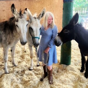 corporate-training A woman in a training area with three donkeys